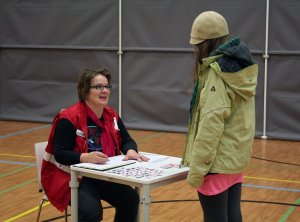 Päivi kirjaa oppilaan tiedot evakuointipöytäkirjaan, kuva: Mika Korppinen