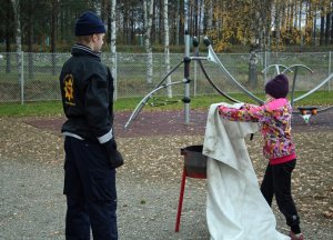 Pelastuslaitoksen Enon yksikkö opettaa lapsille rasvapalon sammuttamista sammutuspeitteellä, kuva: Mika Korppinen